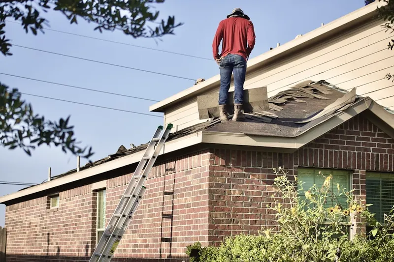 Professional roofer working on a residential roof in Simons